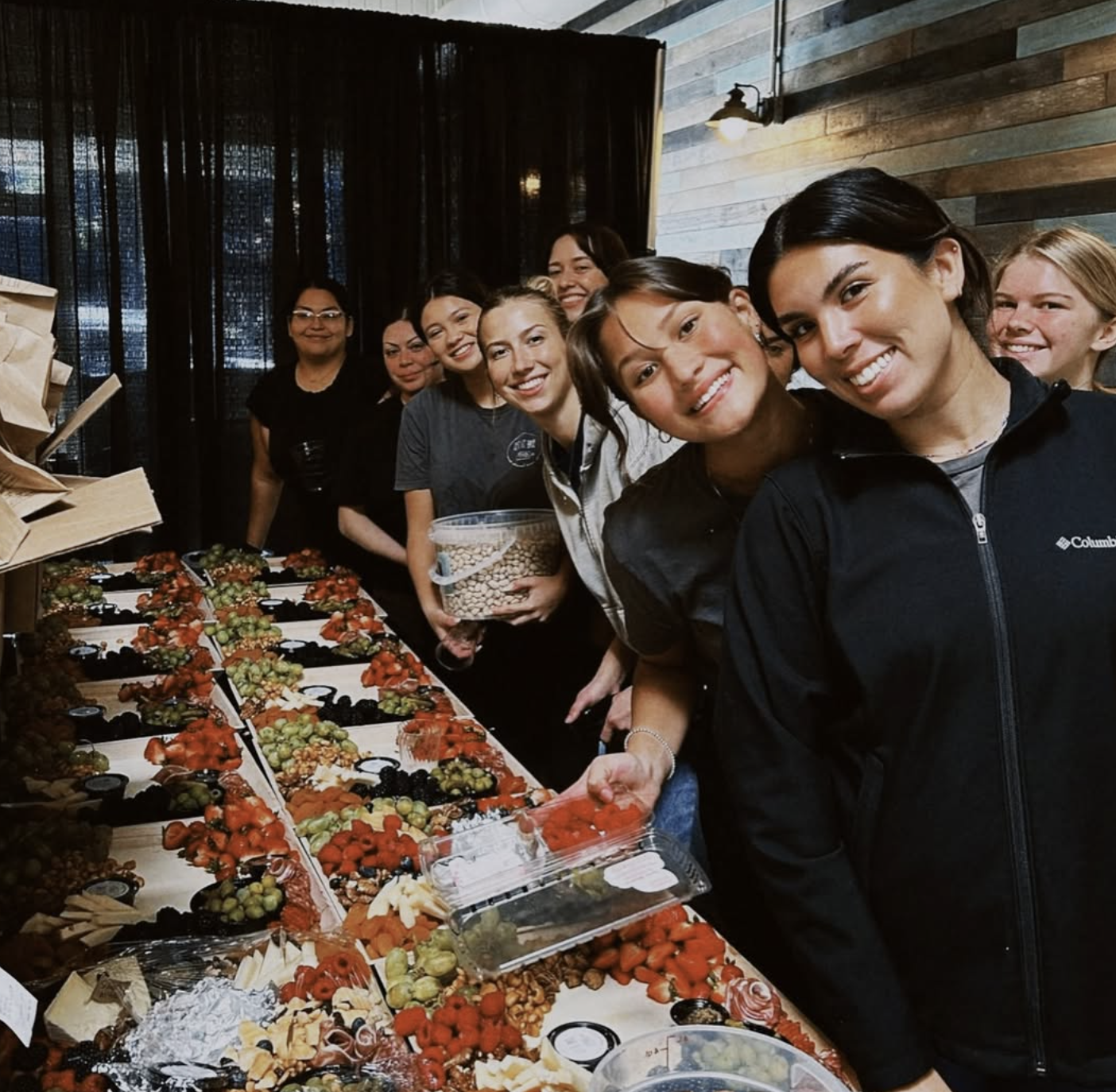 The Let It Brie team assembling a long line of catering boards together